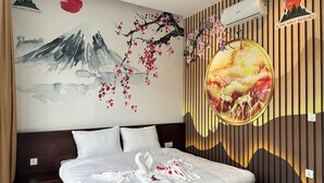 Een hotelkamer met een bed, een muurschildering en een decoratief paneel.