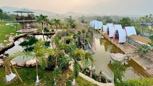 Een resort met een zwembad, palmbomen en een prieel.