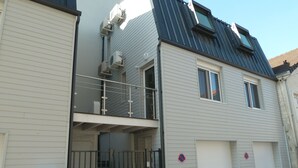 Ein zweistöckiges Wohnhaus mit Balkon, Garage und befestigtem Eingang.