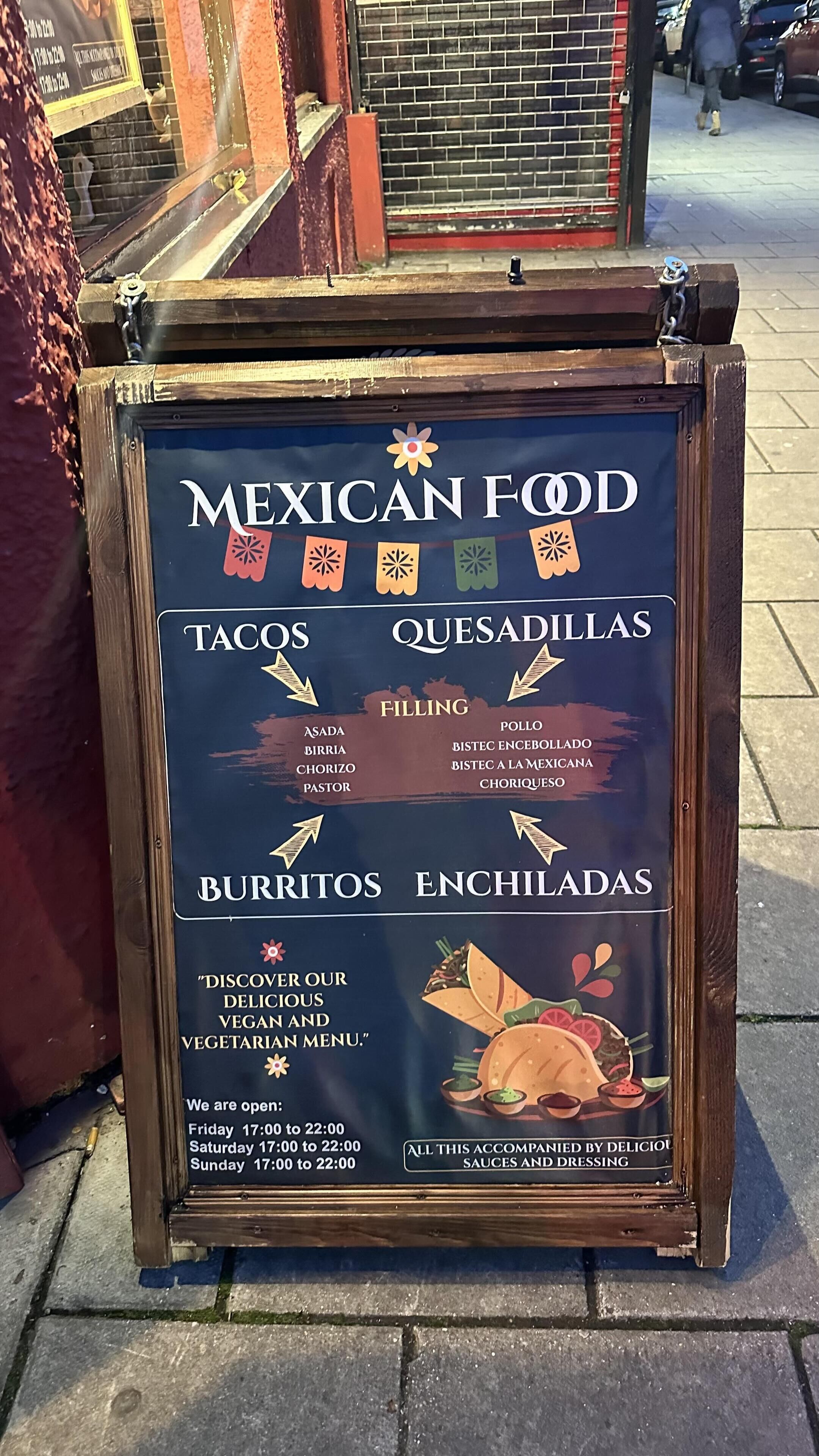 A menu board for Mexican food with taco, quesadilla, burrito, and enchilada options.
