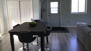 Een eetgedeelte met een tafel, stoelen, een deur en een raam.