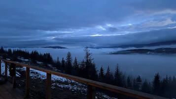 Une vue panoramique depuis un point de vue élevé, surplombant un lac entouré de collines boisées.