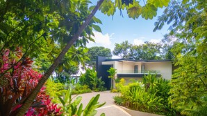 A modern house surrounded by lush greenery. - Casa Colibri by Pura Villas (Uvita)