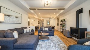 A modern living room with a grey sofa, a coffee table, and a fireplace. - Tremblant Prestige - Verbier 13-102 (Mont-Tremblant)