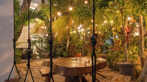 An outdoor seating area with a swing set, a round table, and benches. - HOTEL CARACOL ISLA MUJERES (Isla Mujeres)