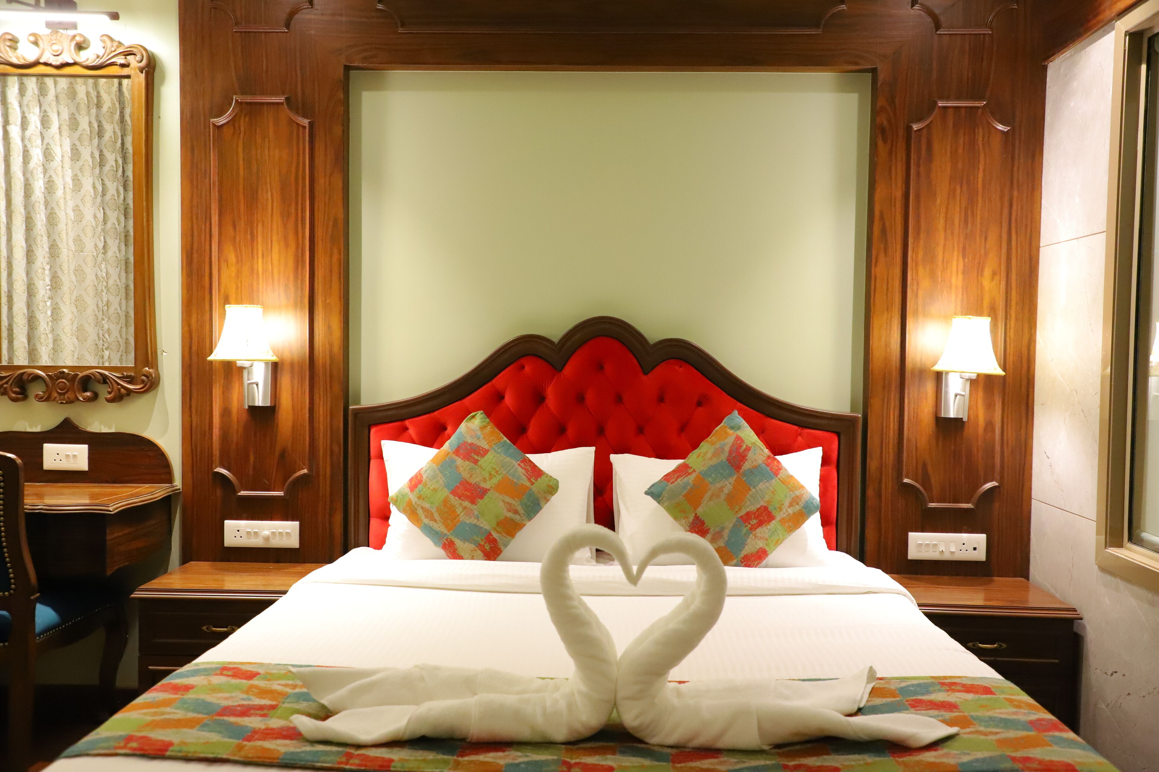 Ein Hotelzimmer mit einem großen Bett, zwei Kissen, einem Schreibtisch und einem Stuhl.