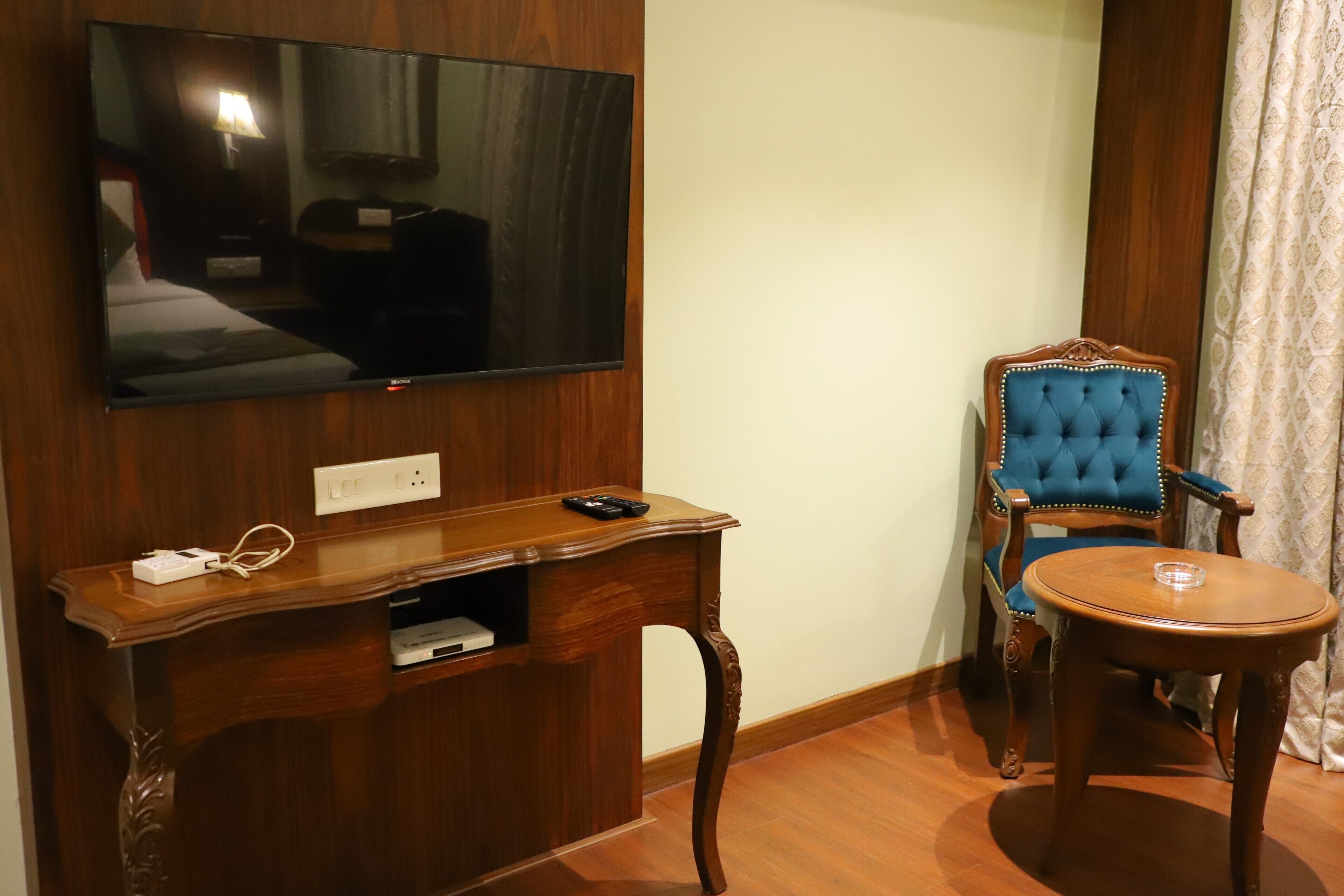 A wooden entertainment unit with a flat-screen TV, a remote control, and a power strip.
