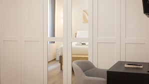 A hotel room with a bed, a chair, a small table, and a television. - Navona Modern apartment (Rome)