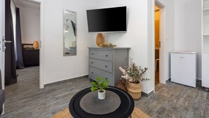 A modern living room with a flat-screen TV, grey storage unit, and a small refrigerator. - Modern flat with WiFi, air conditioning, 850 metre beach (Crikvenica)