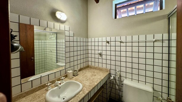 Une salle de bain avec un lavabo, un miroir et une fenêtre.