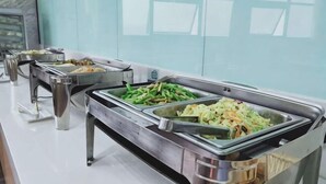 Ein Buffet mit verschiedenen Speisen in Metallbehältern.
