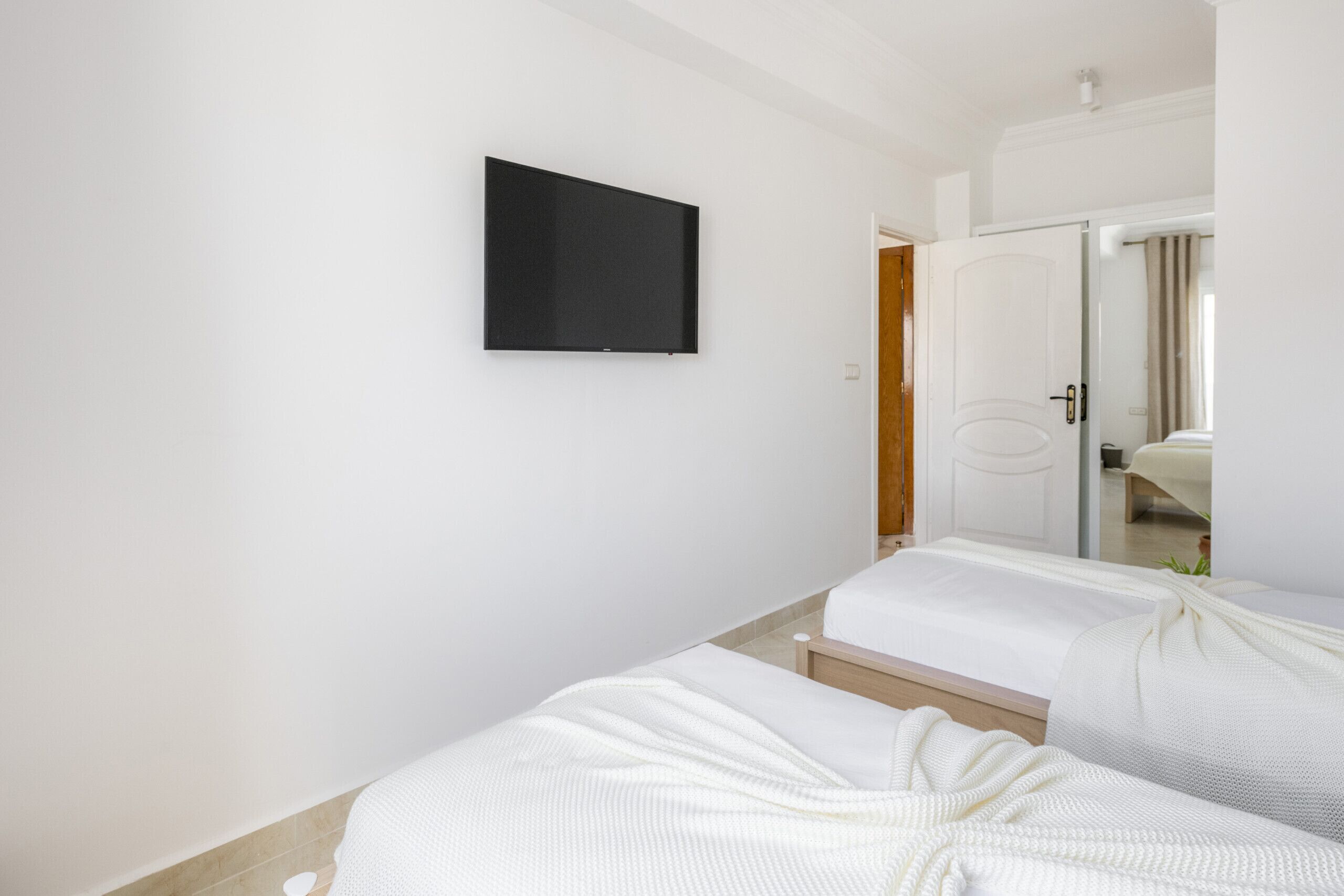 This inviting bedroom features two twin beds, perfect for a comfortable stay for two guests and a flat screen TV.