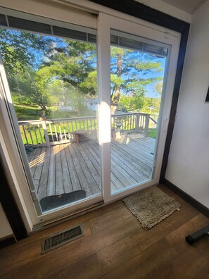 A room with a sliding glass door leading to a wooden deck.