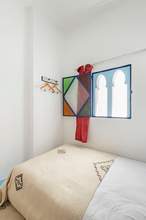 Stained glass window: This bedroom features a beautiful stained glass window that casts colorful light throughout the space. - Dar Yamna Typique Maison de la Kasbah (Tanger)