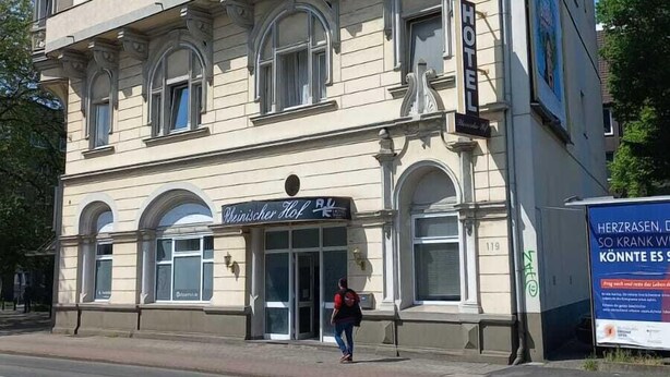 Un edificio de varios pisos con un cartel grande que dice 'HOTEL' en la fachada.