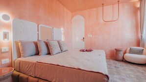 A bedroom with a large bed, a bedside table, a chair, and a small table. - Casa Amate 61 - Mérida Centro (Mérida)