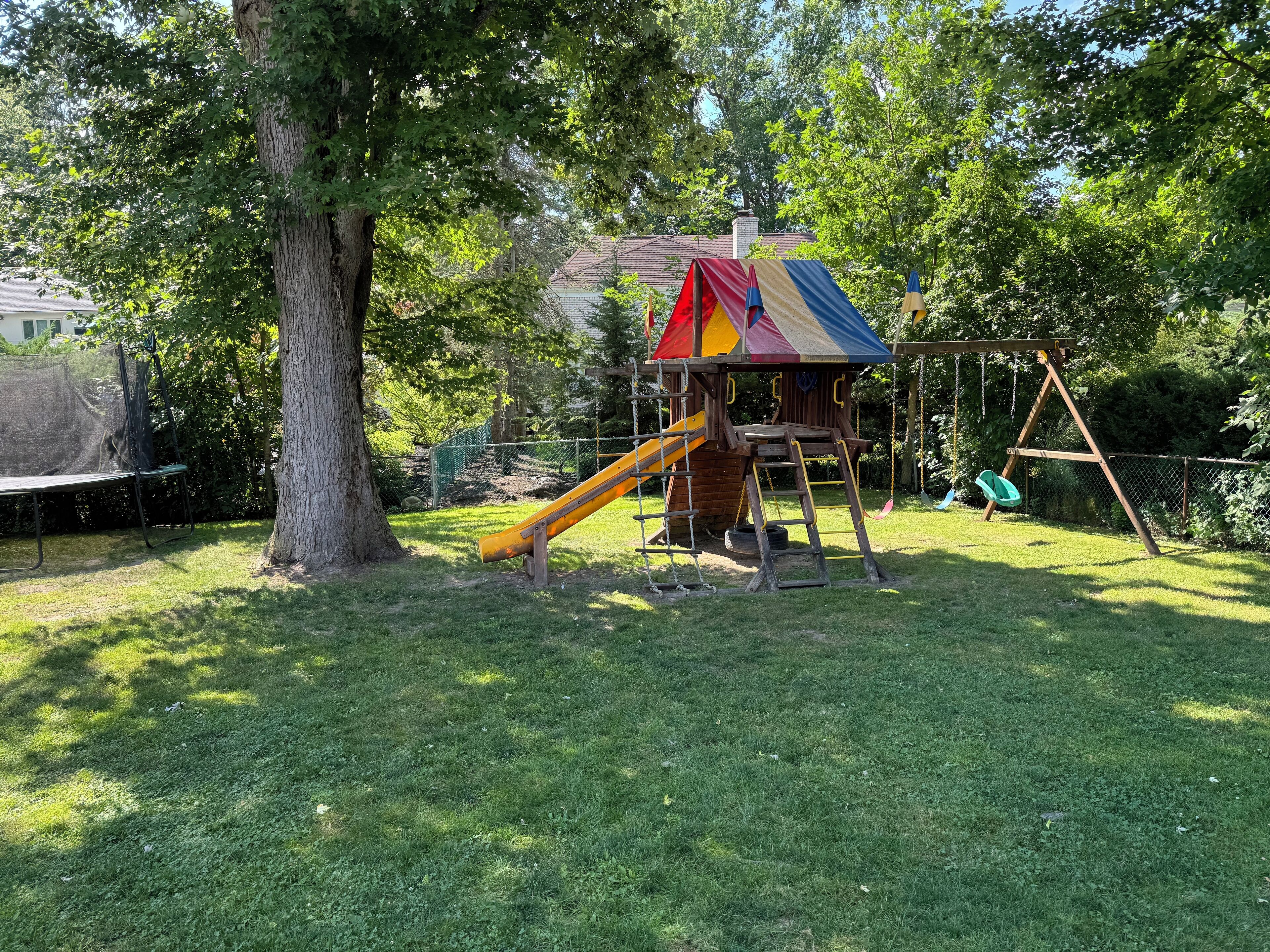 A playground with a slide, swing set, and climbing structure.