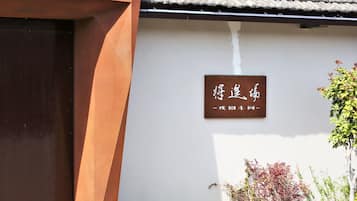 Um edifício com telhado de azulejos tradicionais e uma placa com caracteres chineses.