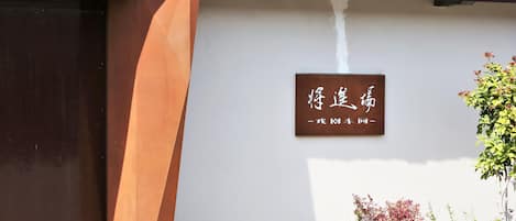 Un bâtiment doté d’un toit traditionnel recouvert de tuiles et d’une enseigne ornée de caractères chinois.