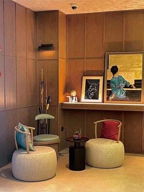 Una sala de estar moderna con paneles de madera, un piano, obras de arte enmarcadas y dos otomanes.