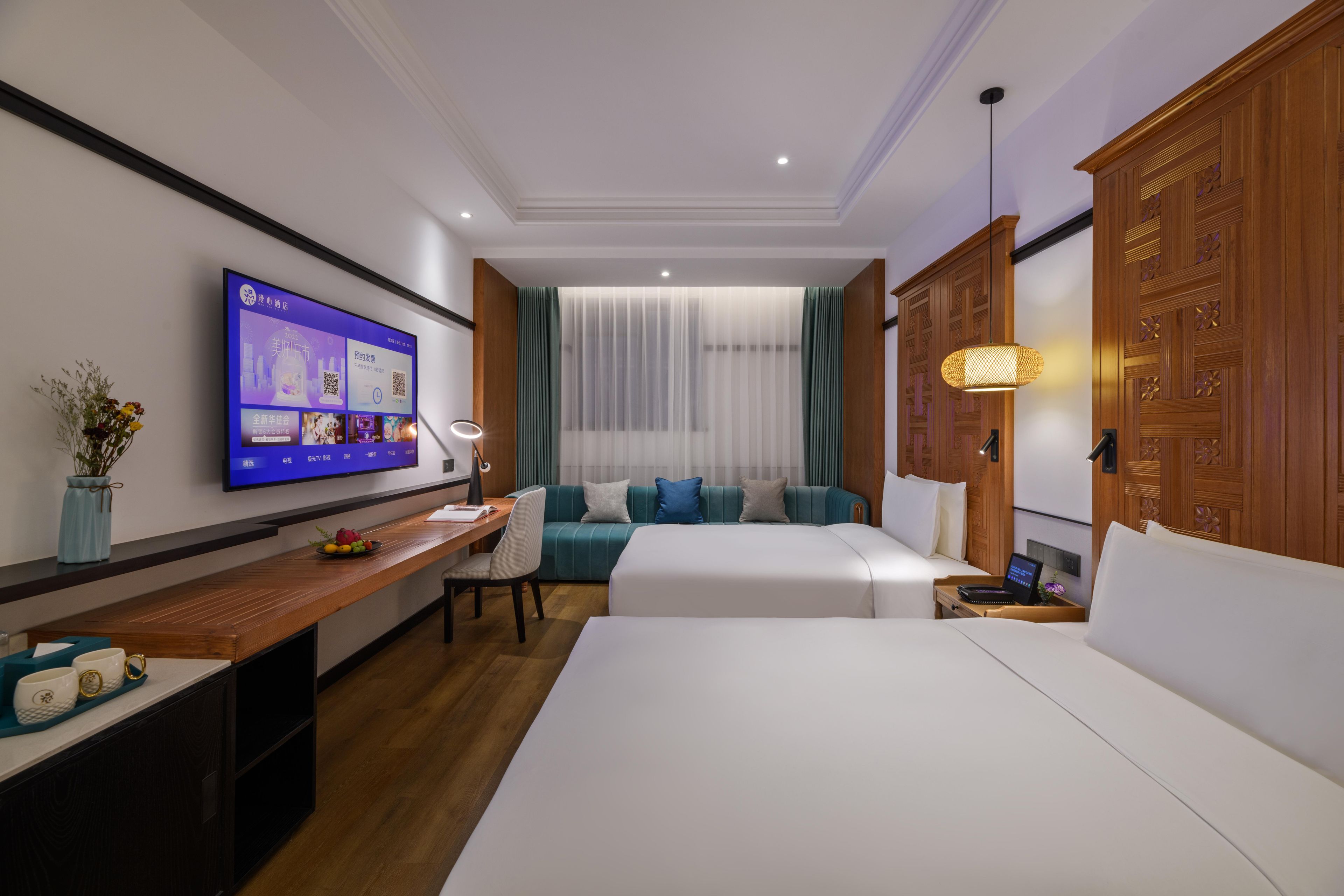 Een hotelkamer met een bed, een bureau, een televisie, een bank en een kledingkast.
