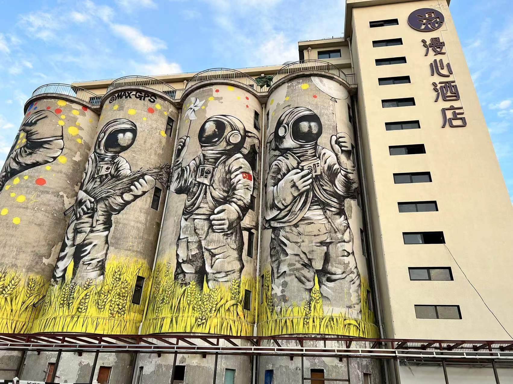 Un bâtiment orné d’une fresque représentant des astronautes et des champs de blé.
