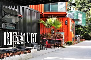 A restaurant with outdoor seating, a large sign, and a red and black building. - Manxin Hotel Shanghai Songjiang Yunjian (Shanghai)