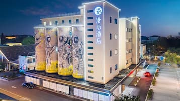 Un hotel de diseño moderno, con un gran mural de astronautas en la fachada.