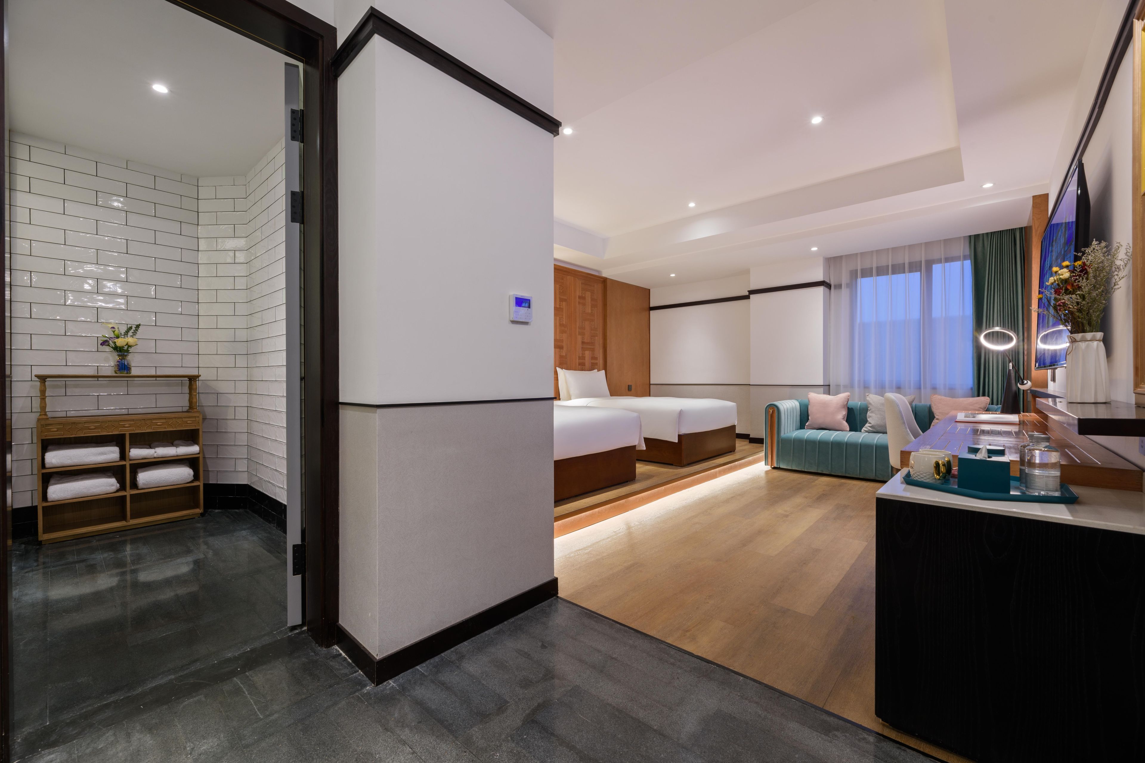 Una habitación de hotel con cama, sofá, pequeño escritorio y zona de baño.