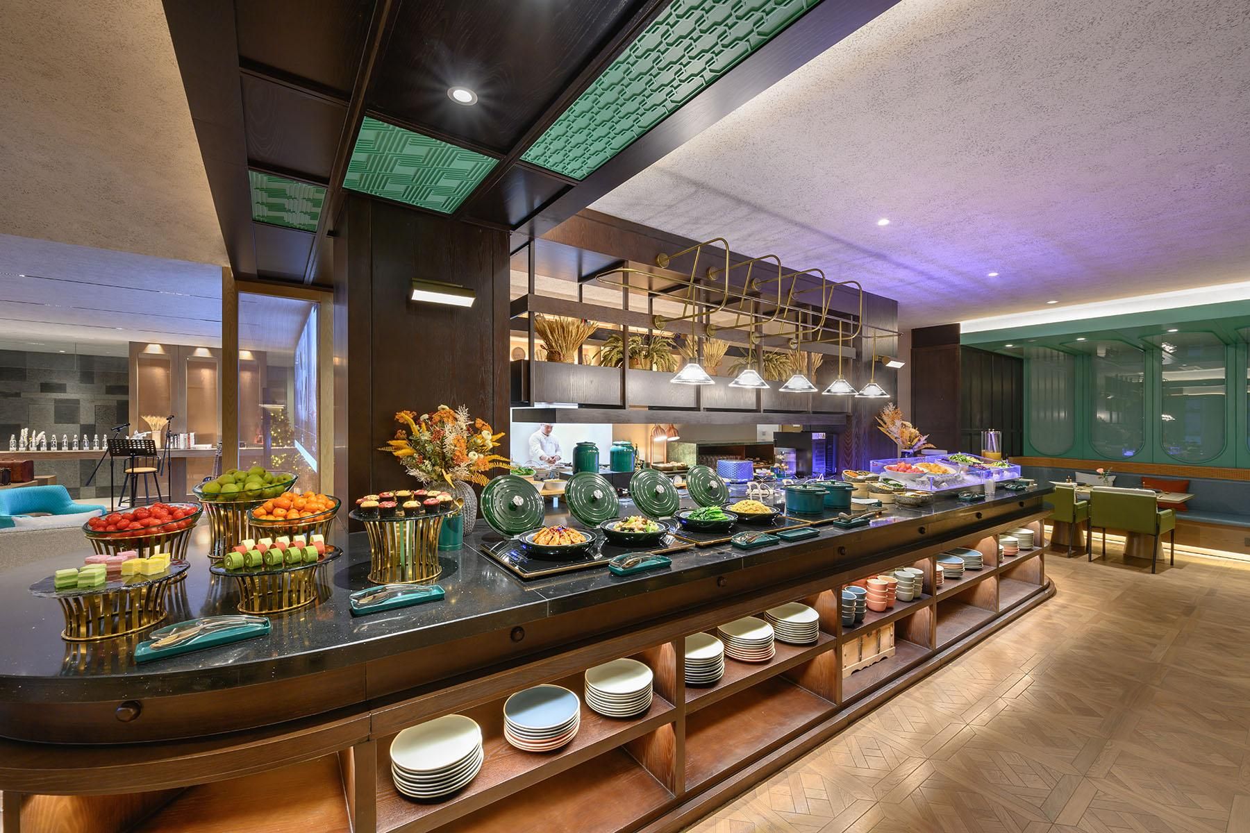 A buffet area with various food items and a seating area with tables and chairs.