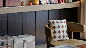 A room with a bookshelf, framed pictures, a vase with flowers, and a decorative figurine. - Manxin Hotel Shanghai Songjiang Yunjian (Shanghai)