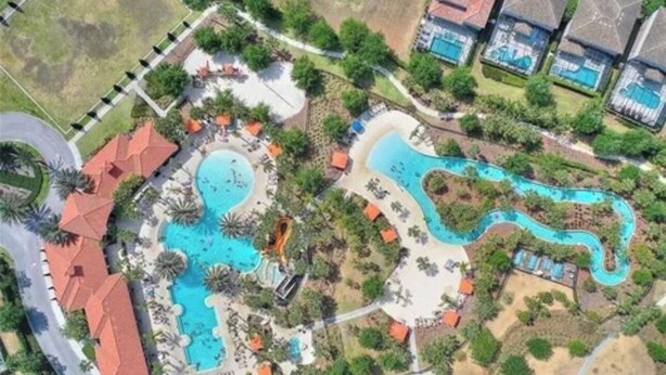 Vista aerea di un resort con diverse piscine, palme e edifici dell'hotel.