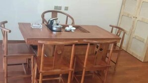 Un tavolo da pranzo in legno con quattro sedie, un bollitore e una teiera sopra.