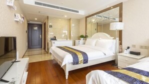 Una camera d'albergo con un letto, comodino, lampada e uno specchio grande.
