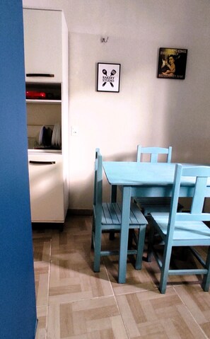 A room with a blue table and chairs, a white cabinet, and a framed picture on the wall. - Casa das Flores (Jijoca de Jericoacoara)