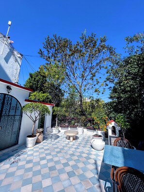 Relax in a serene outdoor space surrounded by lush greenery and a quaint gazebo.