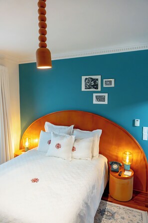 Relax in a spacious room with a large bed, white bedding, and decorative pillows.