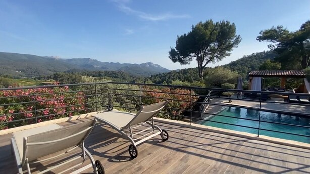 Un espace aménagé au bord de la piscine, avec vue sur les montagnes et agrémenté d’un belvédère.