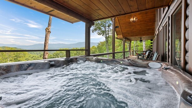 Un bain à remous avec vue sur les montagnes et les arbres.