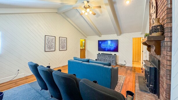 A living room with a blue sofa, a television, and a fireplace. - HUGE Theater Room~ Private Farm Stay- Sleeps 10 (Rome)