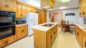 A kitchen with wooden cabinets, a refrigerator, an oven, a microwave, and a dining table with chairs. - HUGE Theater Room~ Private Farm Stay- Sleeps 10 (Rome)