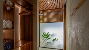 A wooden shelving unit with towels, a wooden ceiling, a wooden lattice partition, and a view through a frosted glass door. - Serenity Wave Bungalow Beach & Jungle Escape + AC (Puerto Viejo de Talamanca)