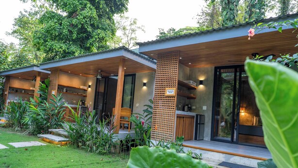 Een modern huis met een overdekte veranda, een houten omheining en een verzorgde tuin.