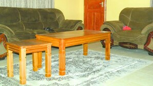 Uma sala de estar com dois sofás, uma mesa de centro de madeira e um tapete estampado.
