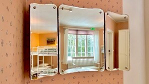 A room with a bunk bed, a window with a view of greenery, and a door. - Herrgård de luxe (Tävelsås)
