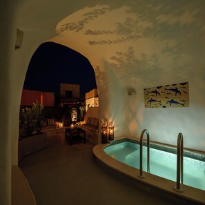 Un área de estar al aire libre con piscina, rodeada de muros con un mural decorativo.