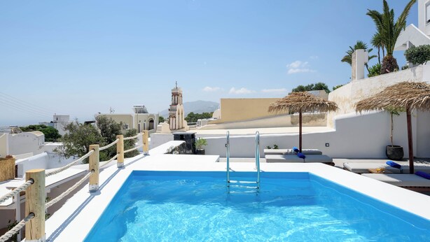 Piscina no terraço com vista clara da paisagem urbana e uma igreja ao fundo.