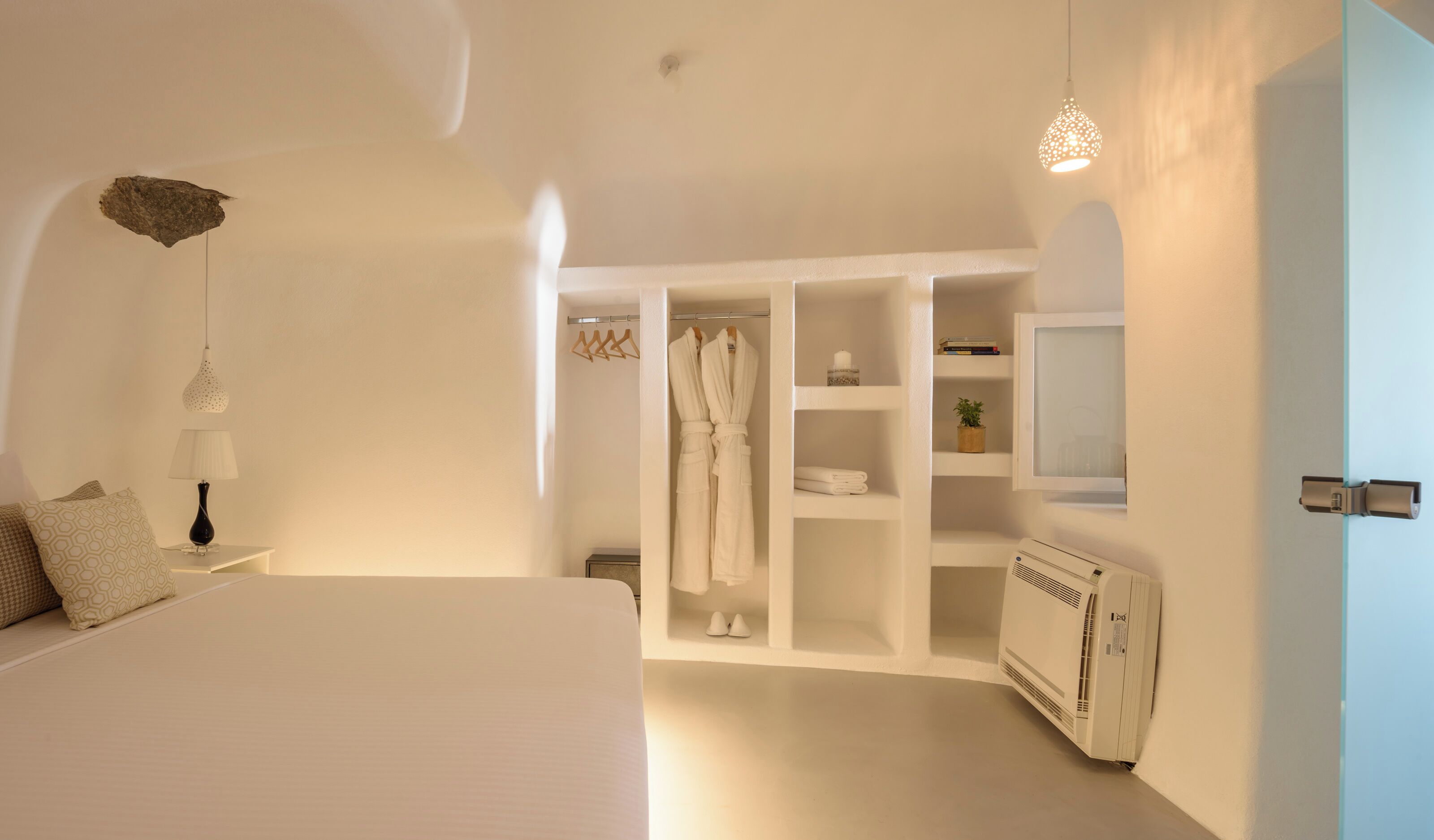 Un dormitorio con una cama grande, un armario, un espejo y un radiador.