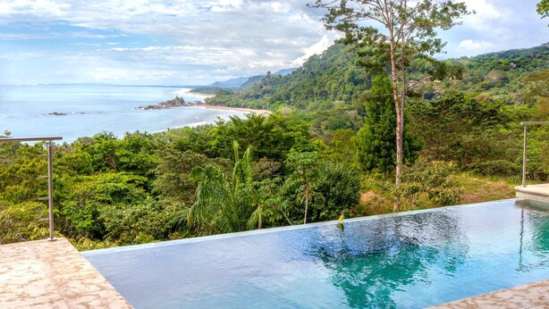 A swimming pool with a view of a beach and lush greenery. - Casa Ola Vista by Pura Villas (Dominical)