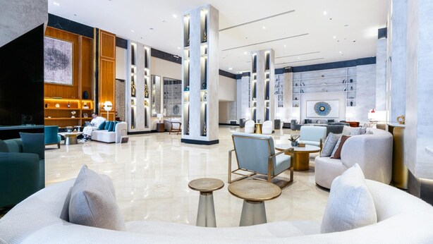 A spacious lobby with high ceilings, modern furniture, and a central column structure. - Novo Hotel (Riyadh)